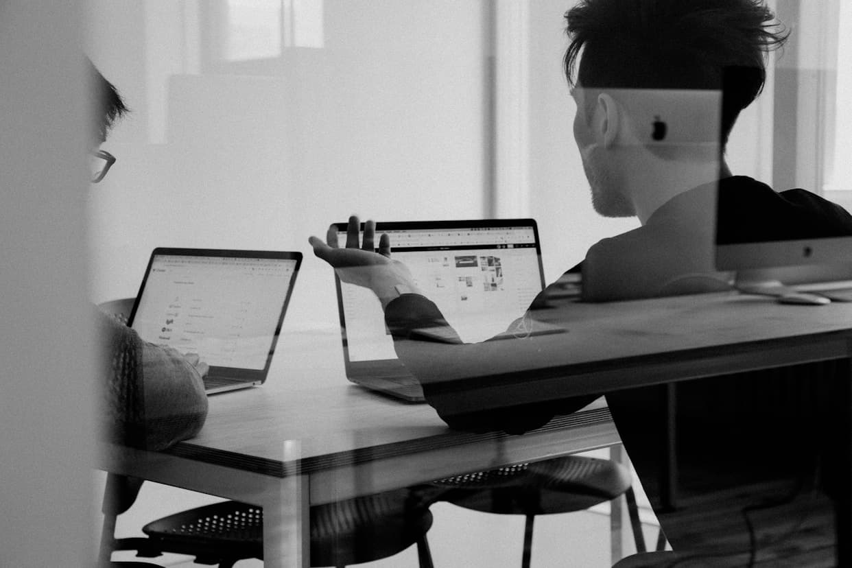 Two teammates reviewing work together at a desk